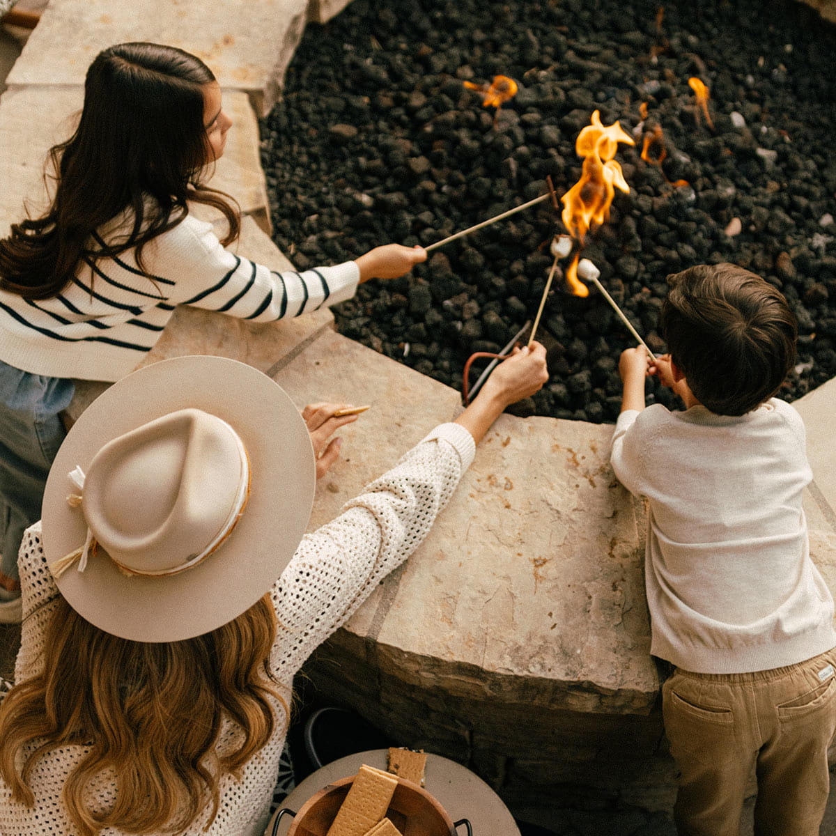 family roasting marshmallows outside 