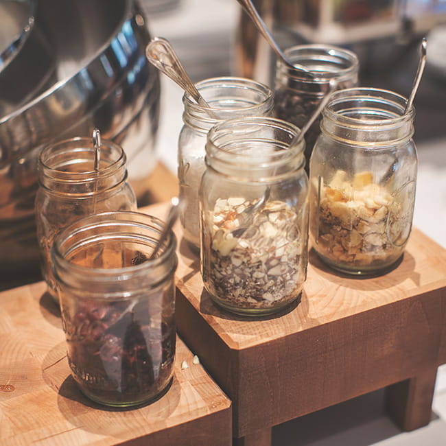 mason jars full of oats and nuts sitting on counter