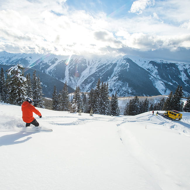 skier skiing powder near snow cat