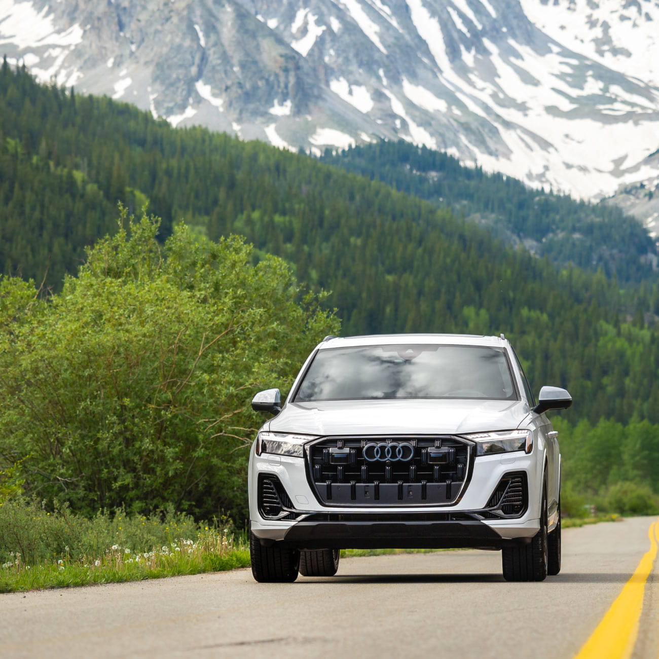 audi car driving on road in front of mountains