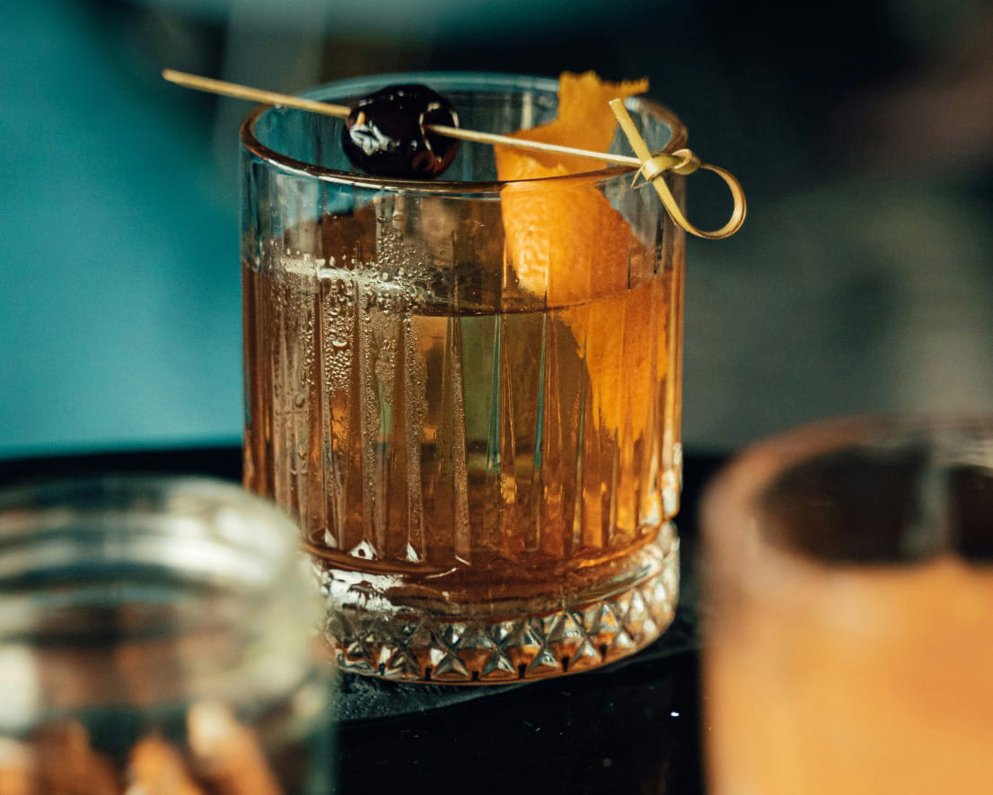 Close-up of whiskey drink with orange peel in a short glass