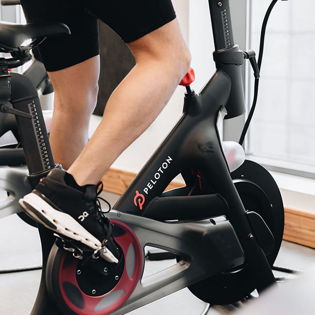 man using peloton bike