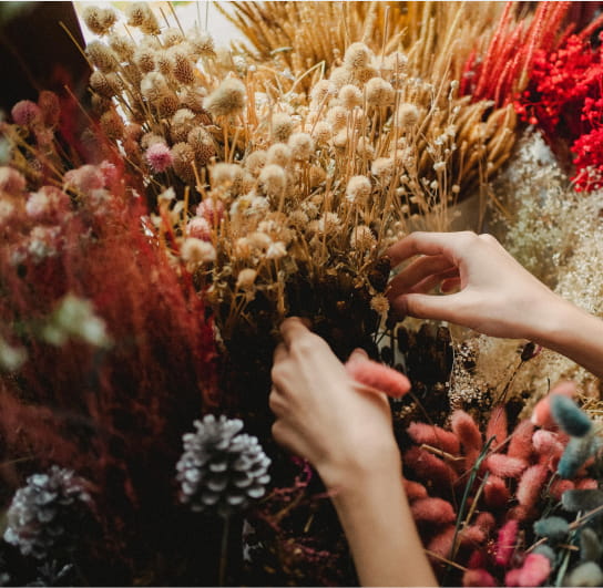 person adjust flower arrangement bouquet