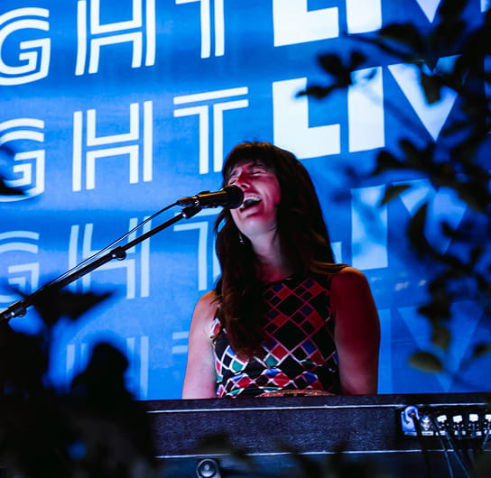 performer singing and playing the keyboard