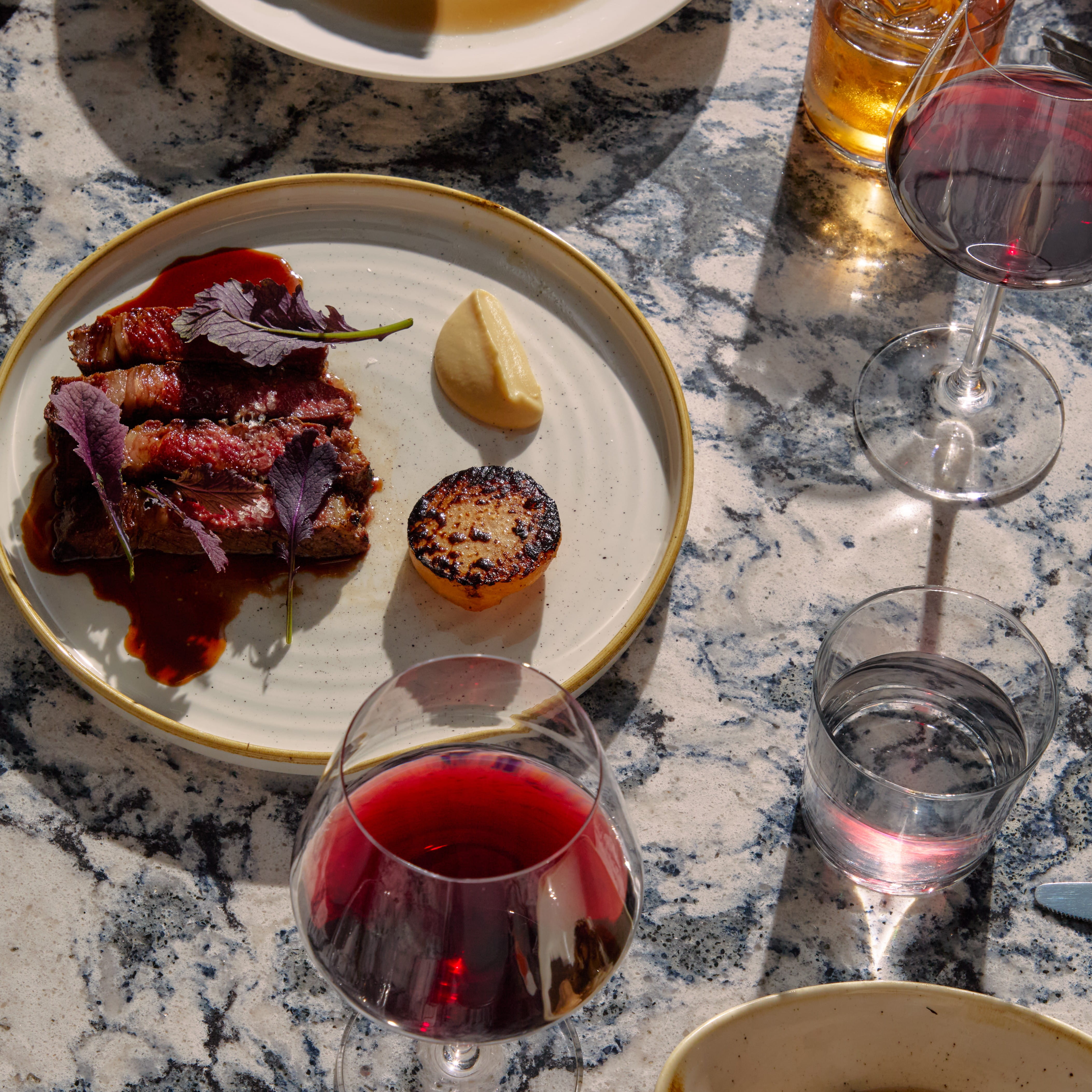 Restaurant table with steak and red wine dinner