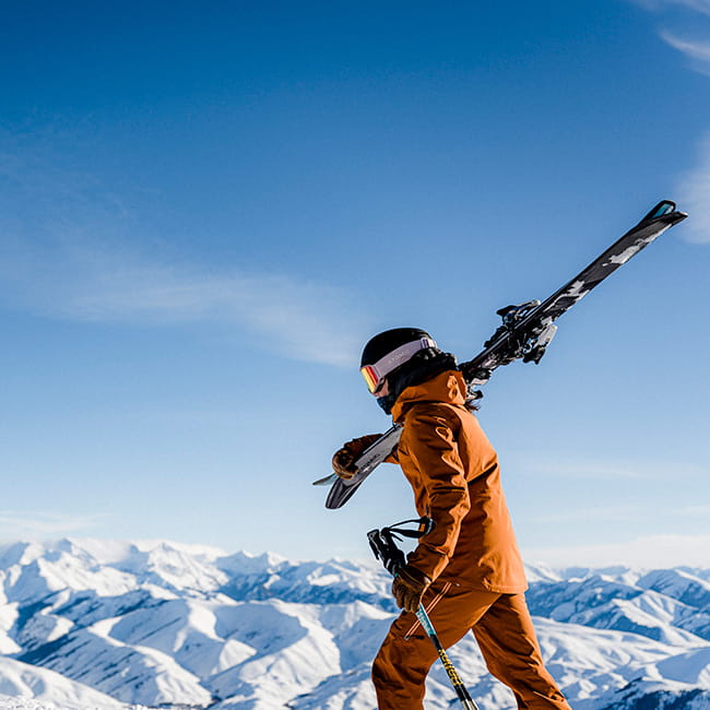 Skier walking on mountain with skis