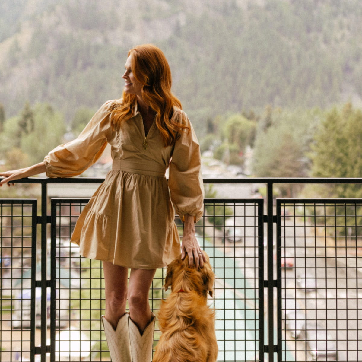 woman with dog on guest room balcony