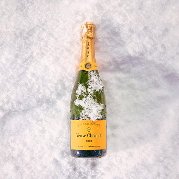 bottle of veuve lying in snow