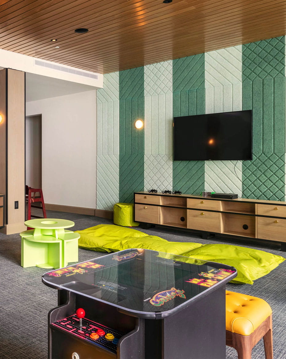 Limelight Snowmass offers an game room for children. With an arcade games, a TV, yellow bean bags, and video game consoles.
