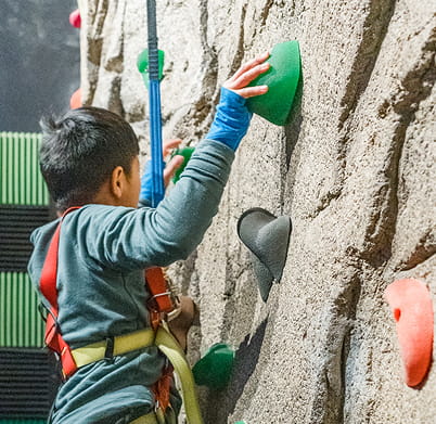 kid climbing on rock wall