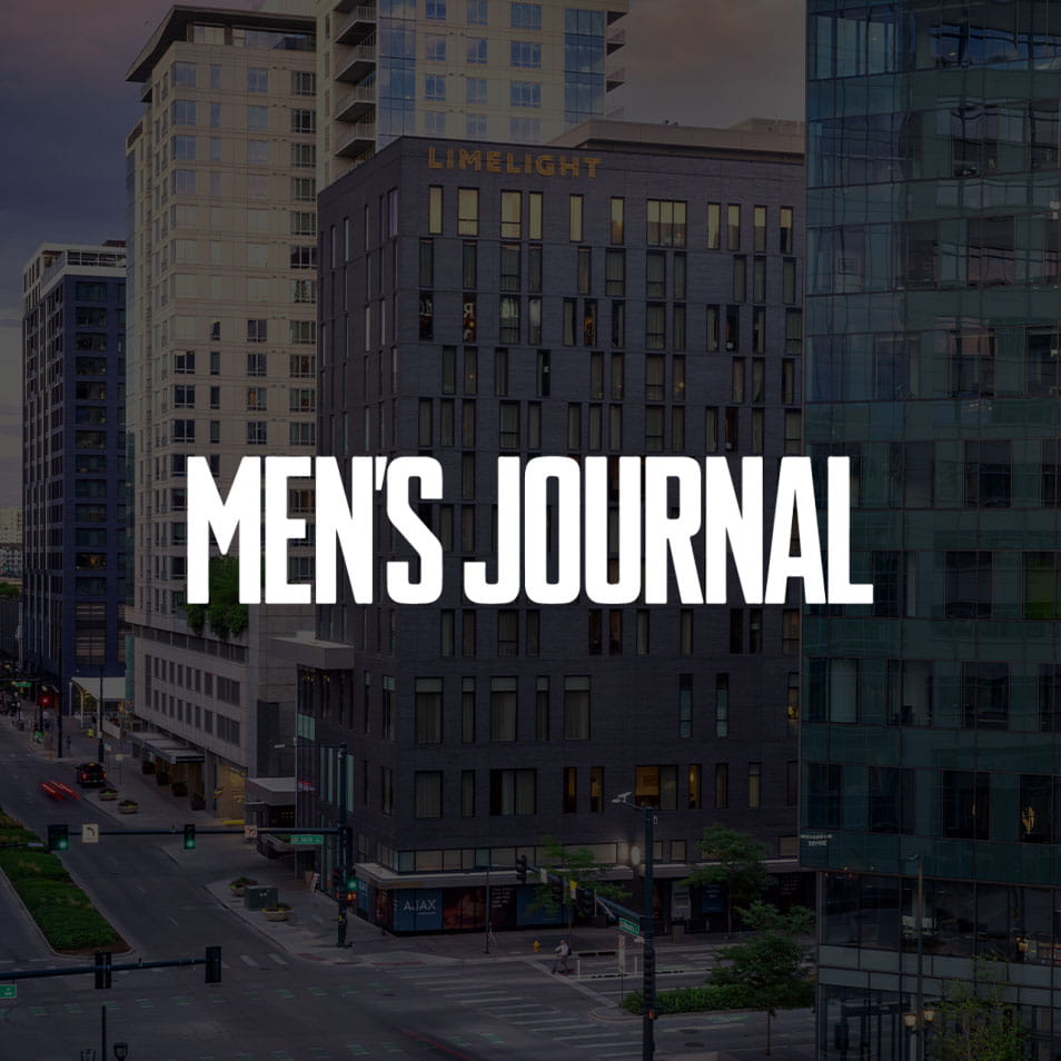 Large "MEN'S JOURNAL" text overlaying an urban scene with high-rise buildings, including one labeled "LIMELIGHT," and a street with cars and greenery in a city setting.