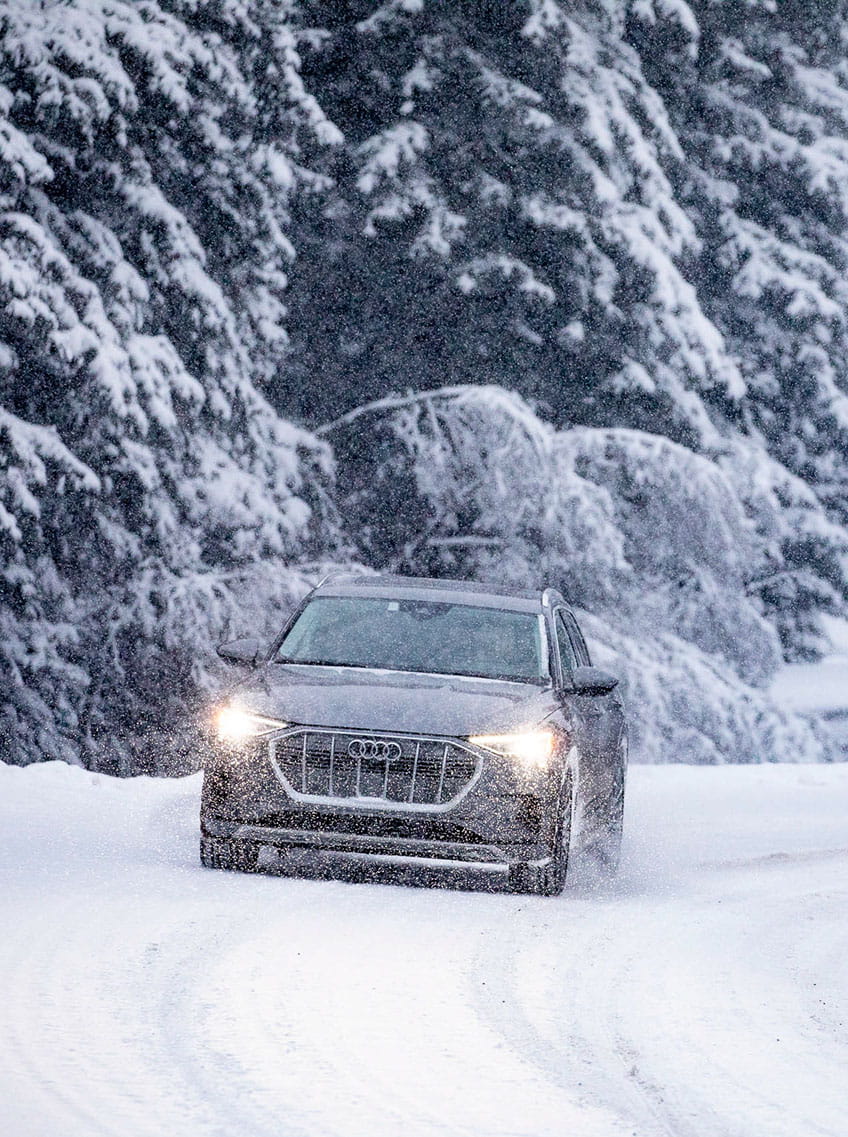 audi car driving on road in snow storm