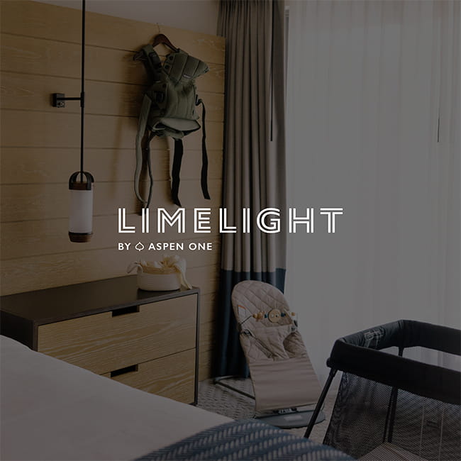 Hotel room with baby carrier and crib, with 'Limelight By Aspen One' logo overlay