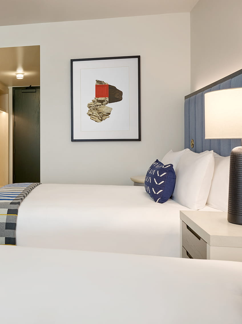 two queen beds and art in guest room