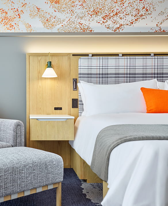 side of bed and chair in guest room