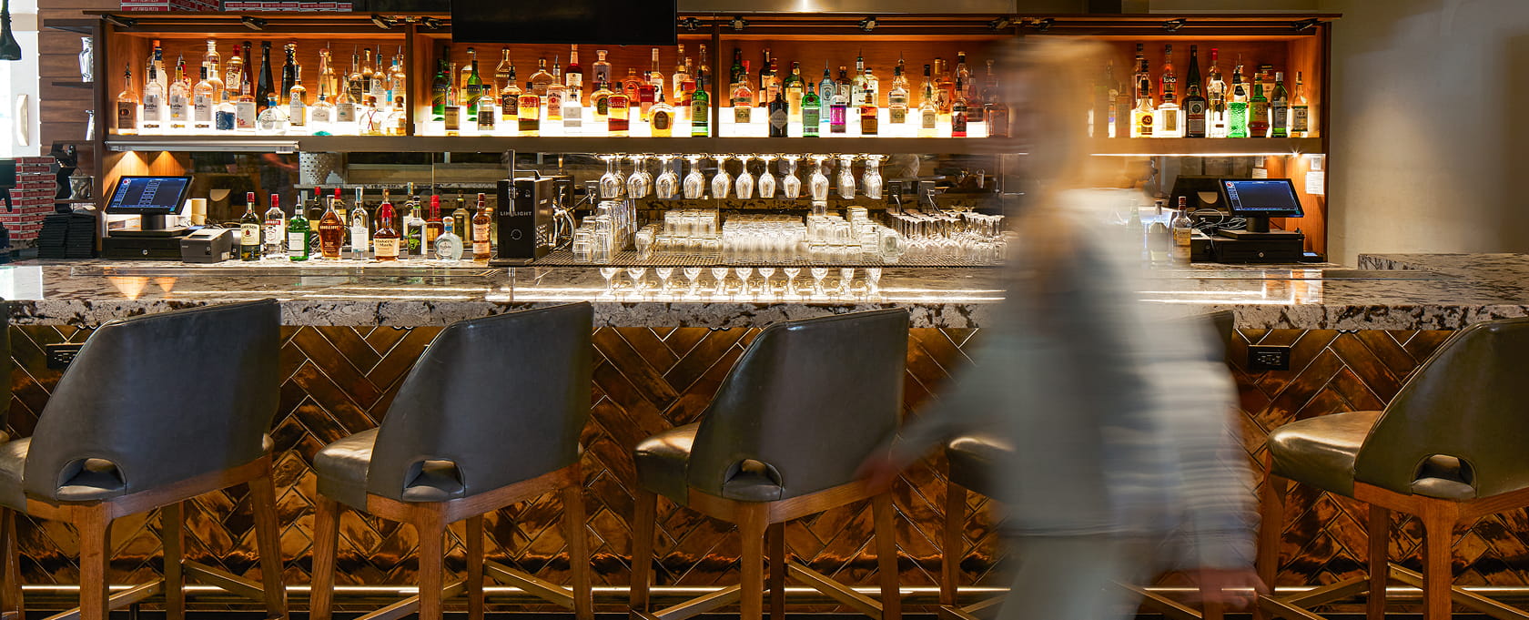 person walking past lounge bar