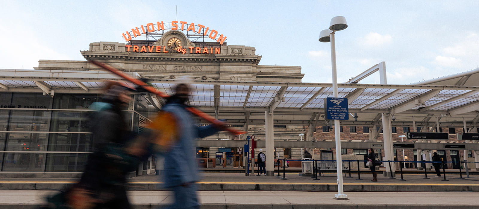 two people with dog walking in front of hotel entrance