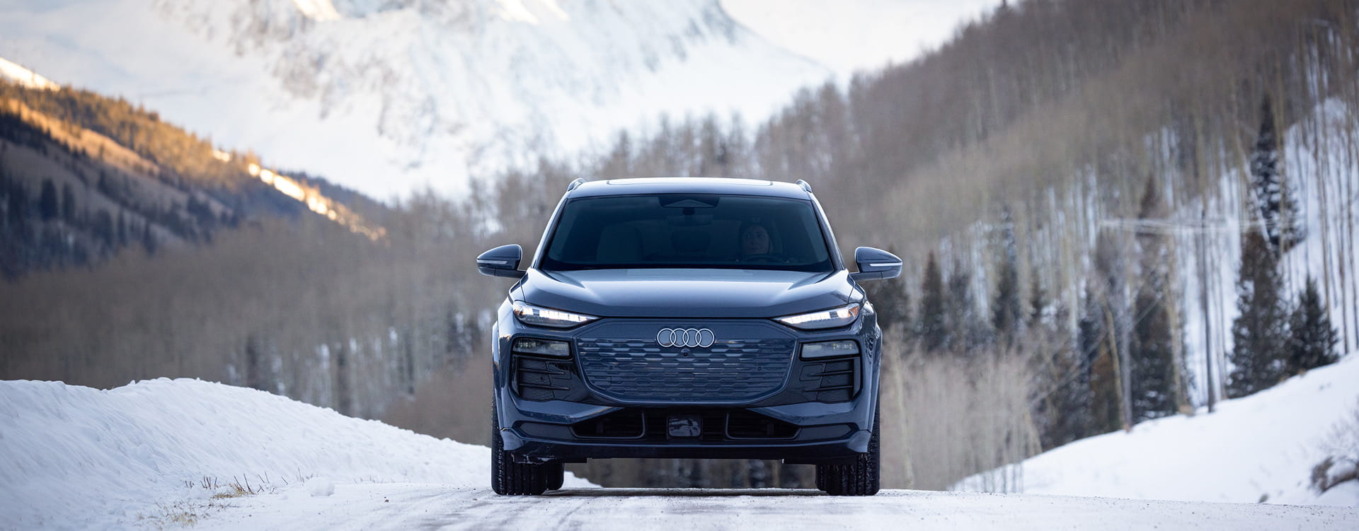 audi car driving on road in front of mountains