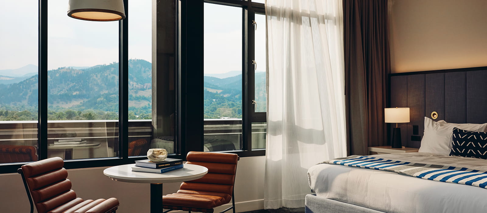 table and king bed in room overlooking flatirons