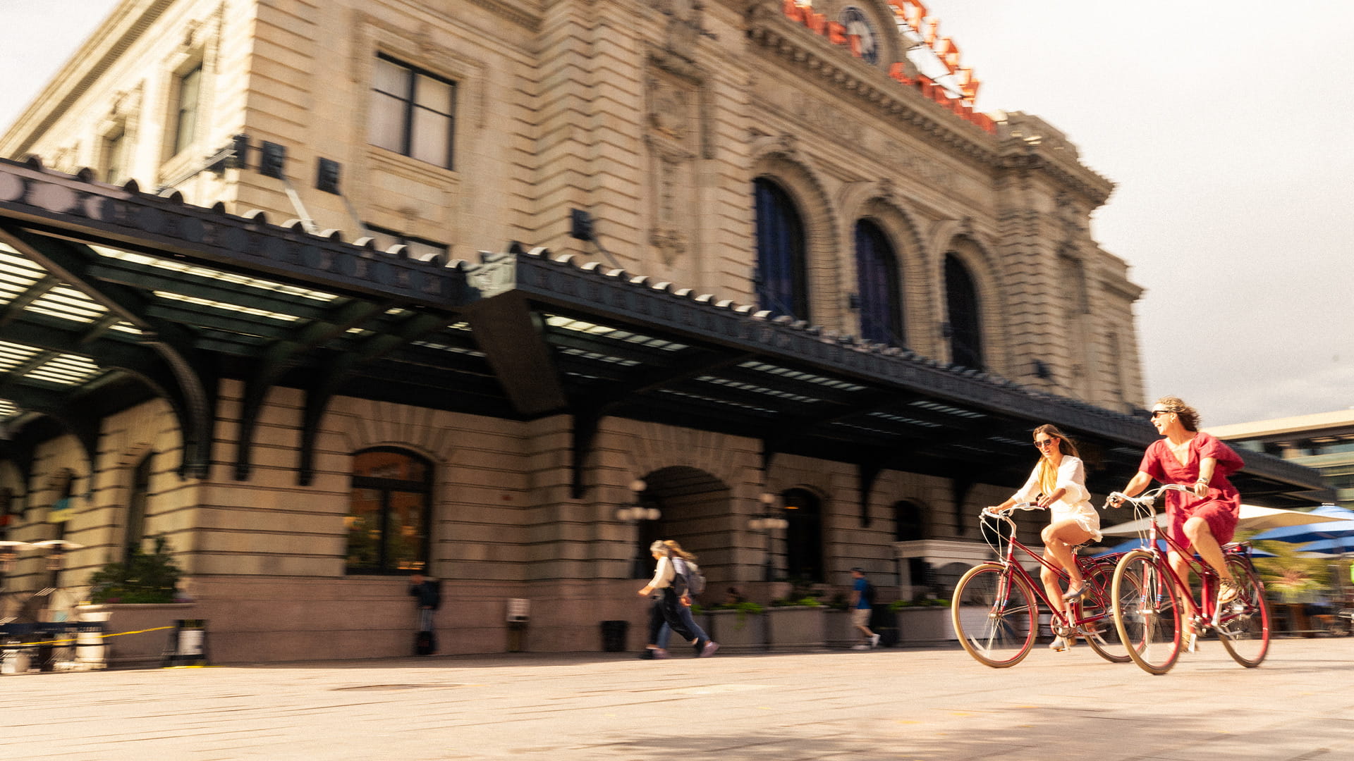 two people biking past union station