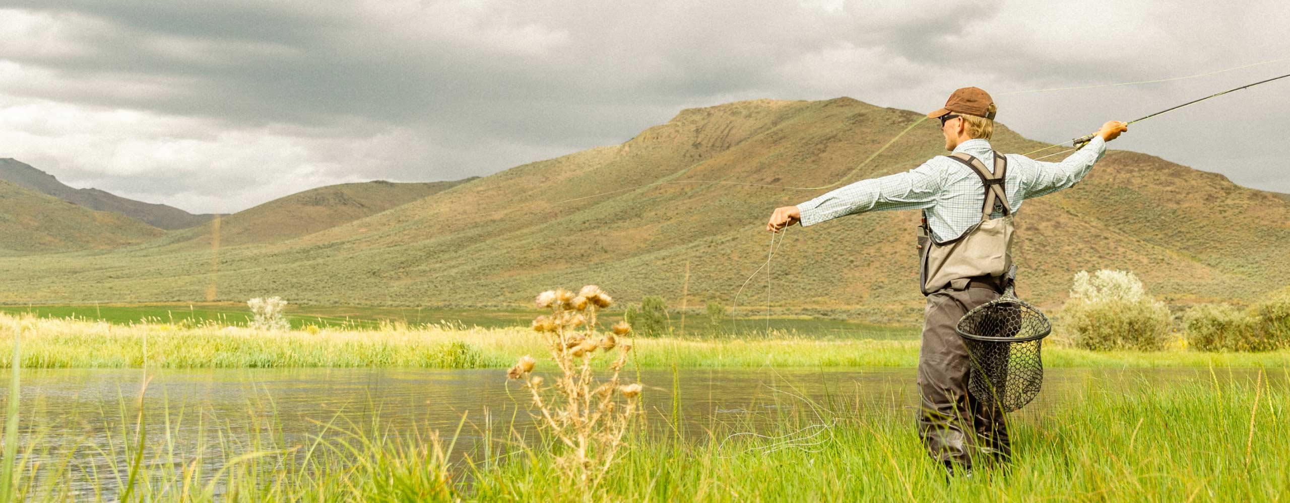 man fly fishing in the mountains