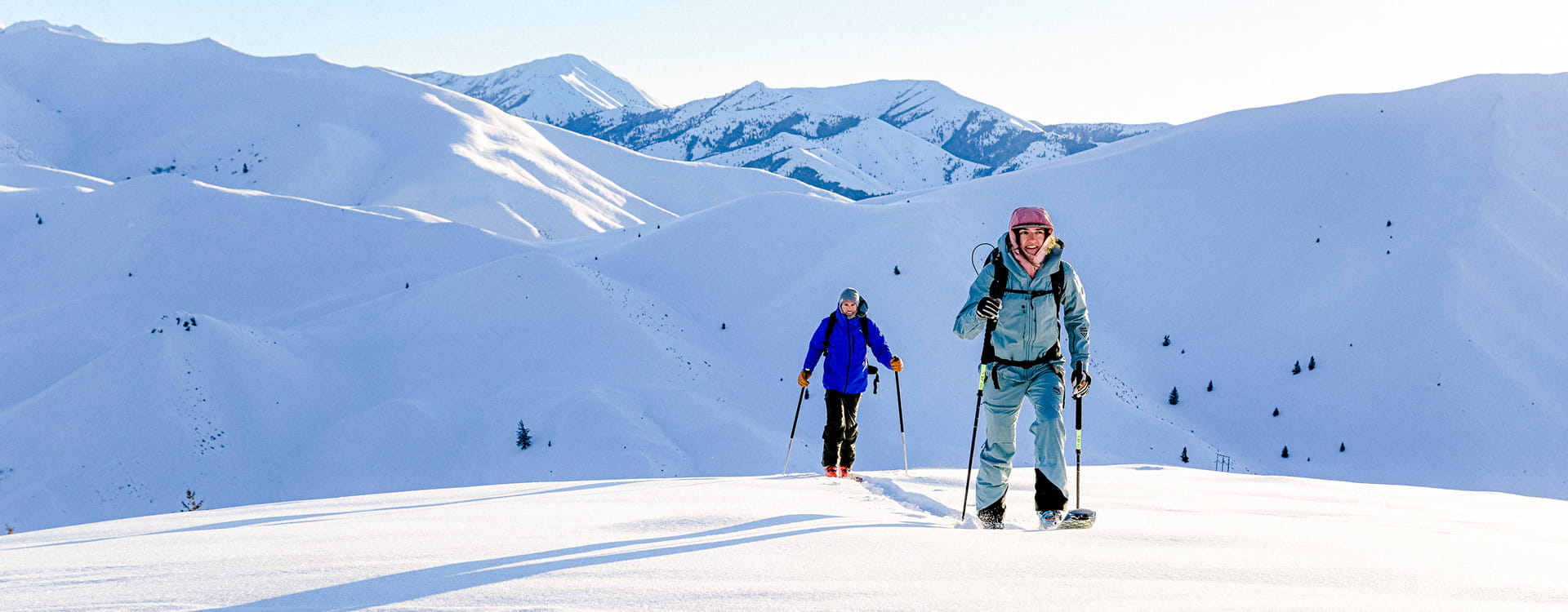 two backcountry skiiers skinning up mountain