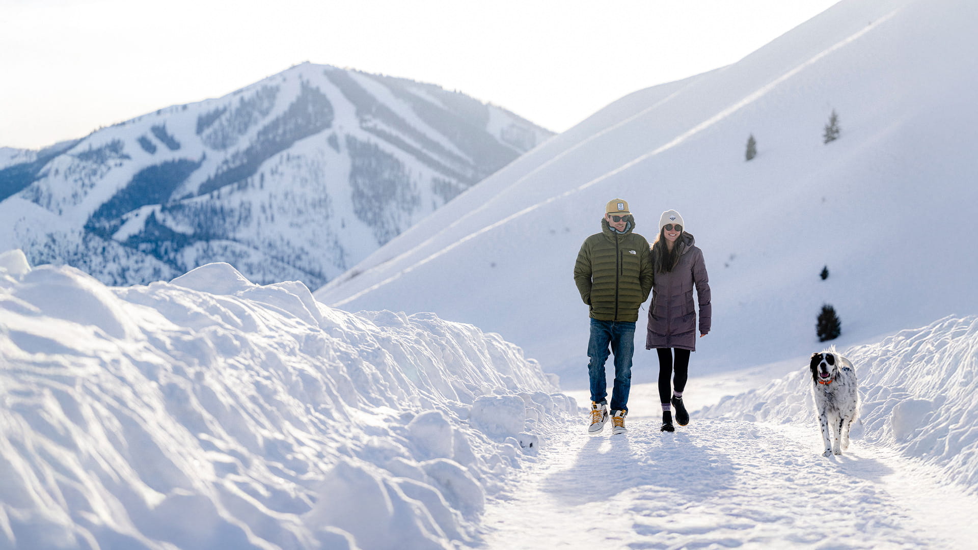 couple walking through snowy mountains