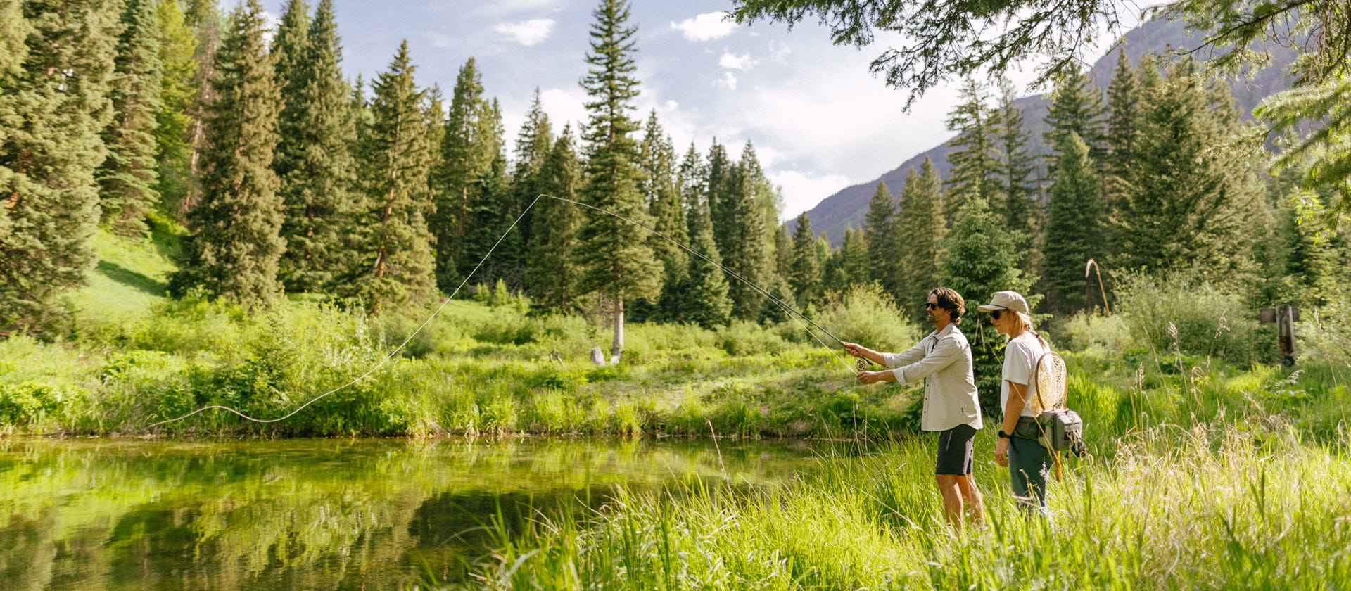 two people fly fishing in mountains