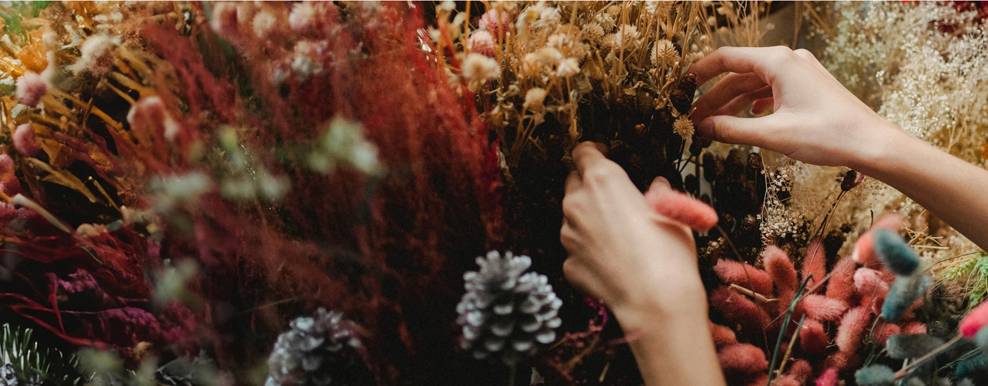 person adjusting flower arrangement bouquet