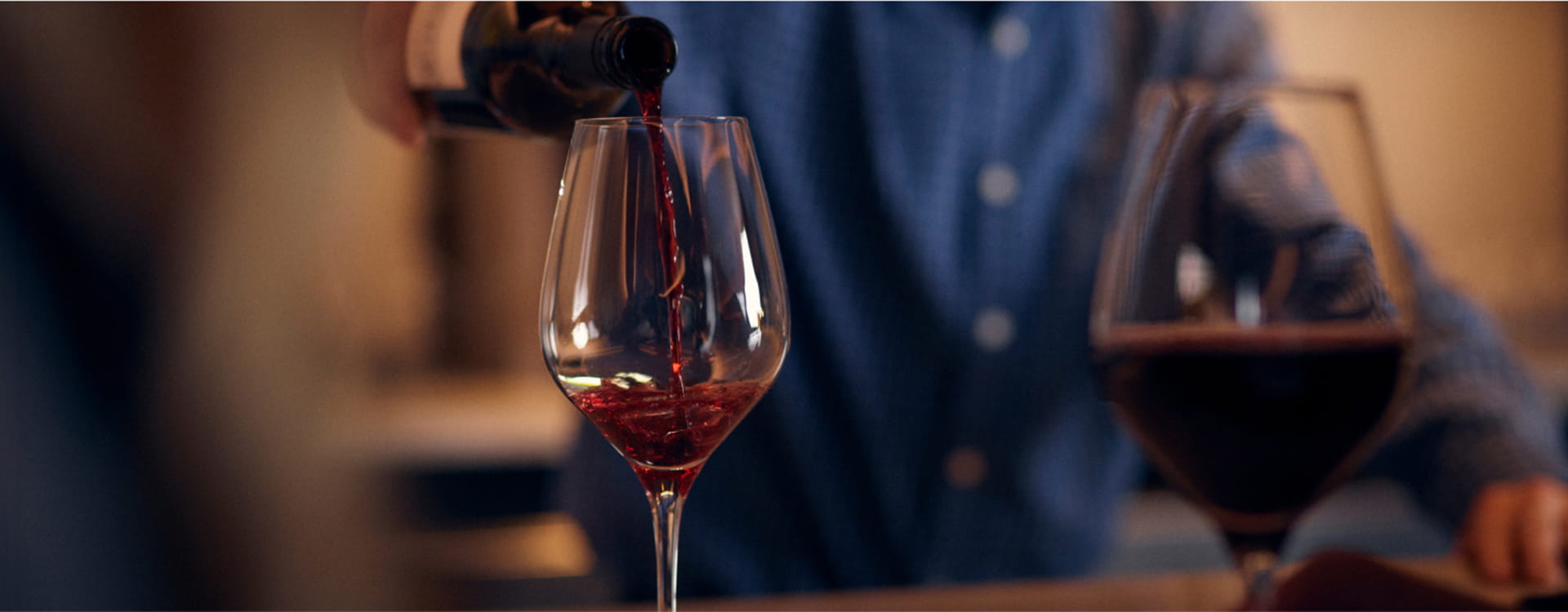 person pouring wine into glass
