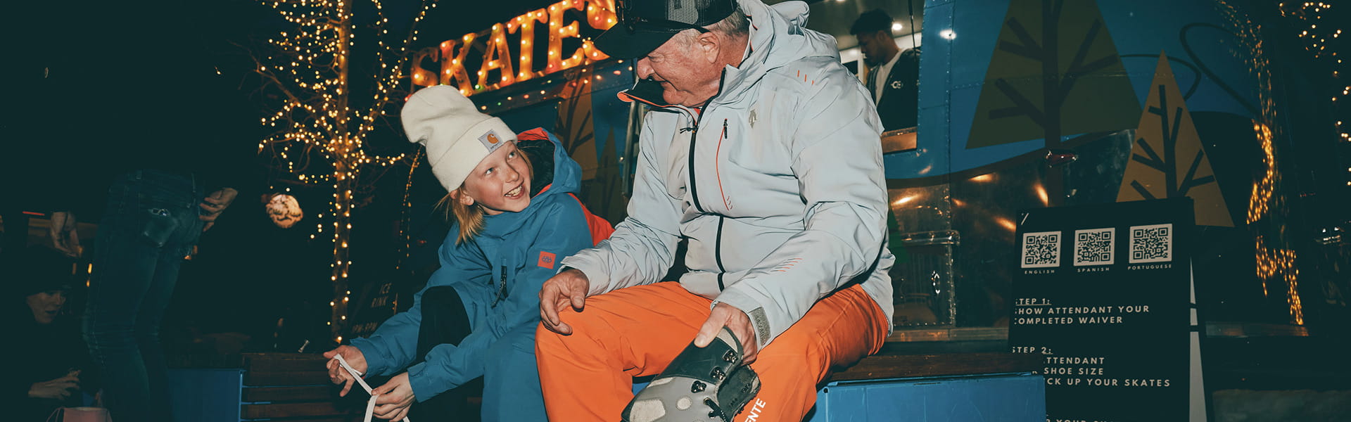kid putting on skates with dad