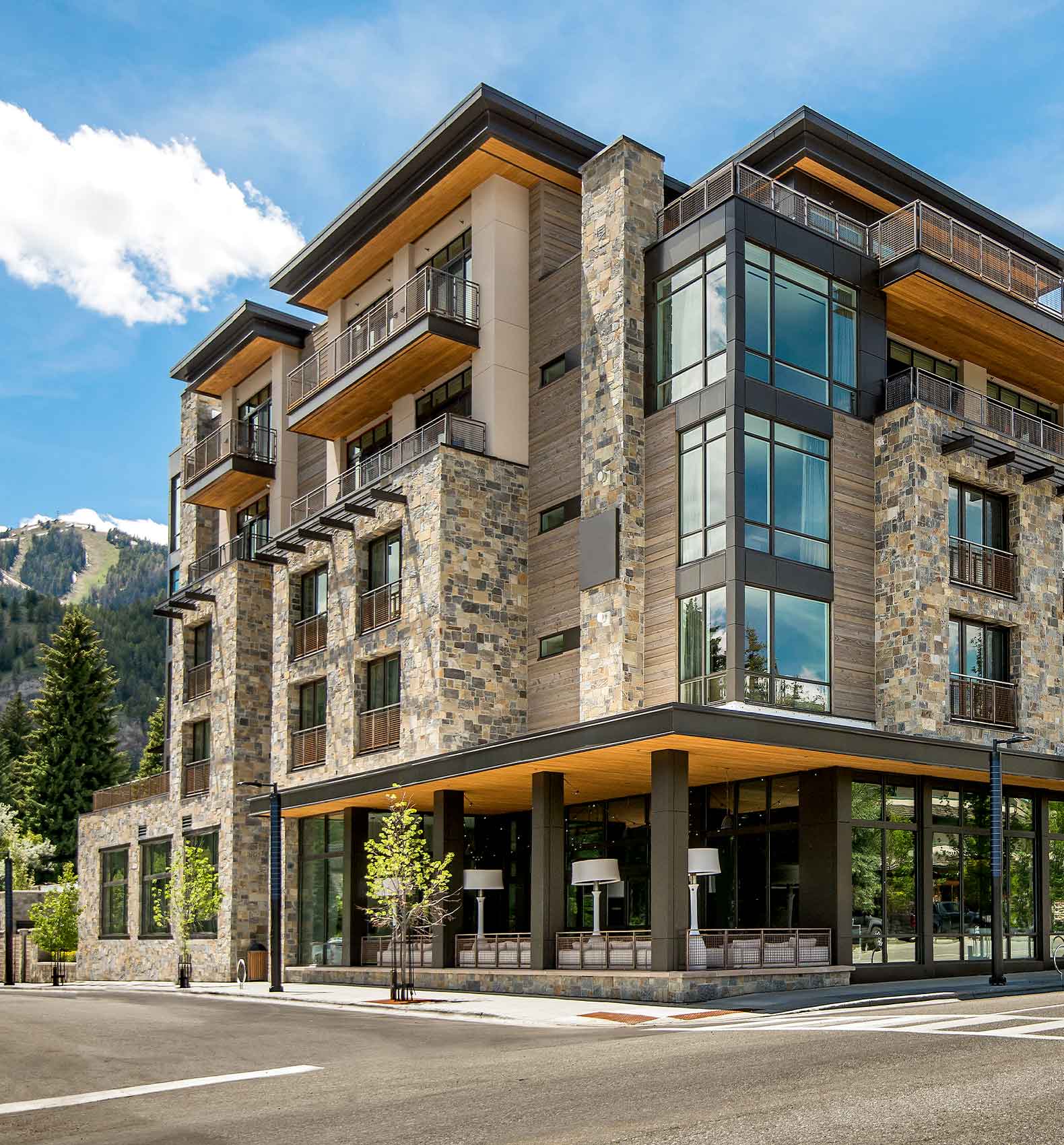 Limelight Ketchum is a multi-story, modern building with stone and glass facade featuring balconies and large windows stands at a street corner.